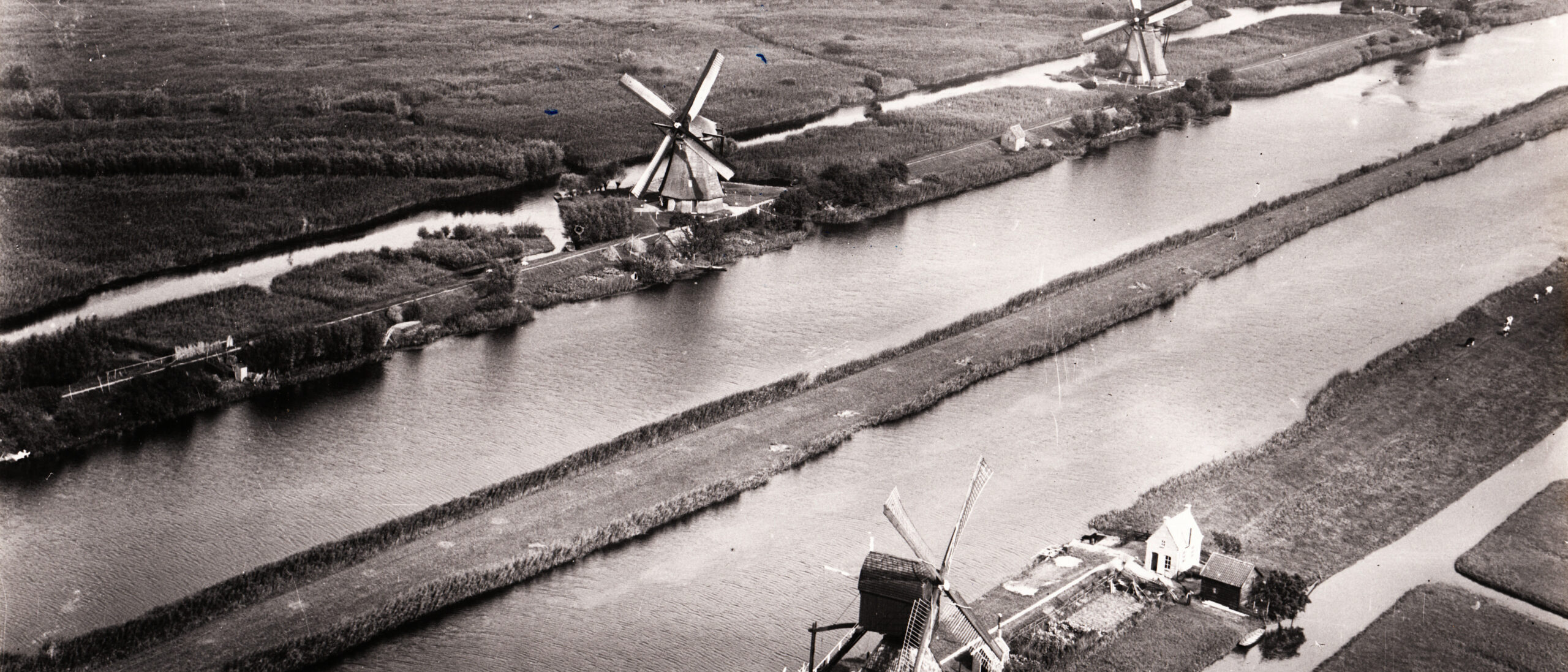 Zwart wit luchtfoto van Kinderdijk. Museummolen Blokweer is hier goed op te zien evenals enkele molens van de Overwaard