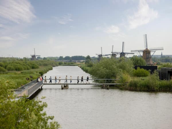 People enter Kinderdijk UNESCO World Heritage via the group entrance bridge. The windmills can already be seen in the background.