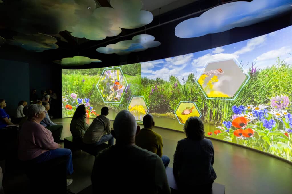 Een groep bezoekers kijken naar de film in Hulpgemaal de Fabriek.