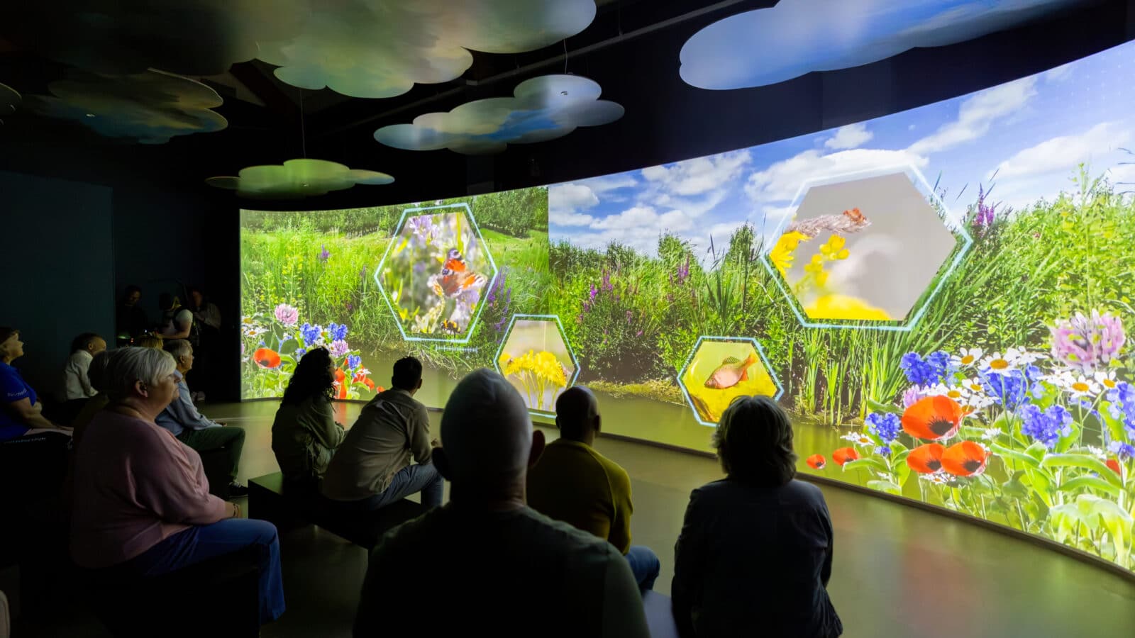 Een groep bezoekers kijken naar de film in Hulpgemaal de Fabriek.