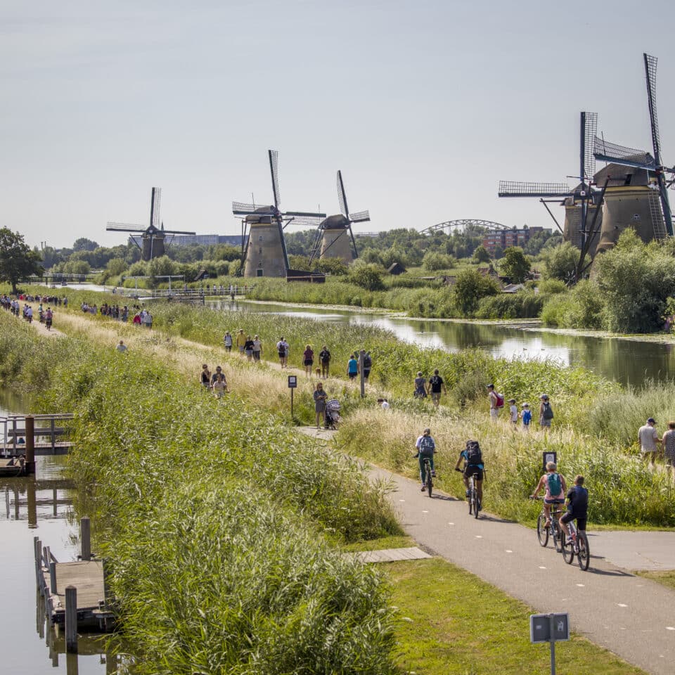 Bezoekers wandelen over de Middelkade door UNESCO Werelderfgoed Kinderdijk