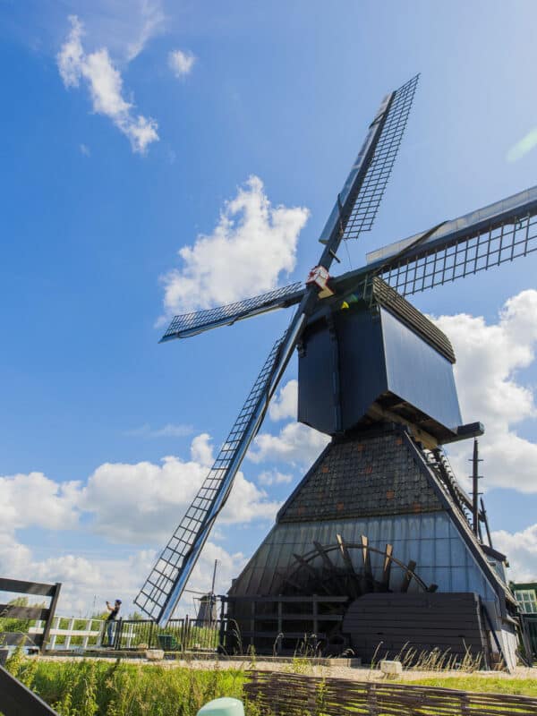 Museummolen Blokweer in Kinderdijk op een zomerse dag met link de Nederlandse vlag die wappert