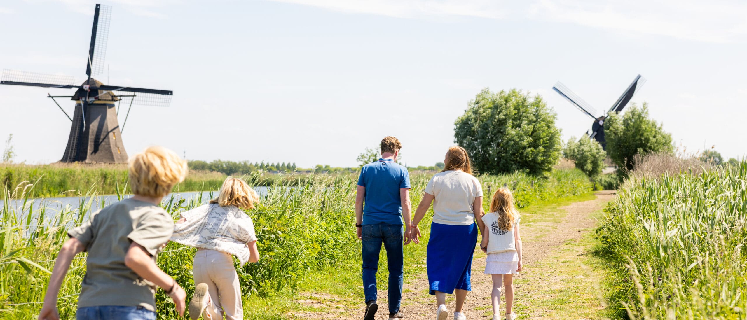 Gezin rennend over het Natuurpad in Unesco Werelderfgoed Kinderdijk