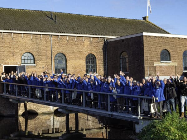 Medewerkers en vrijwilligers van Kinderdijk opgesteld op de brug richting het Wisboomgemaal.