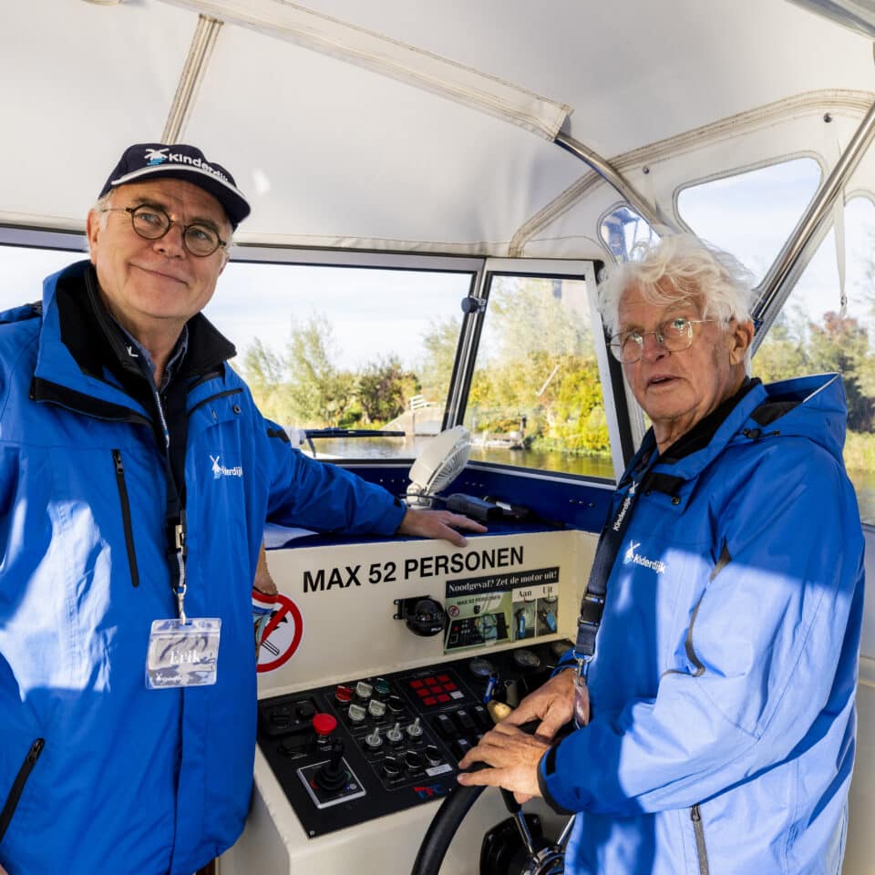 Twee vrijwillige schippers in Kinderdijk aan boord van de rondvaartboot,