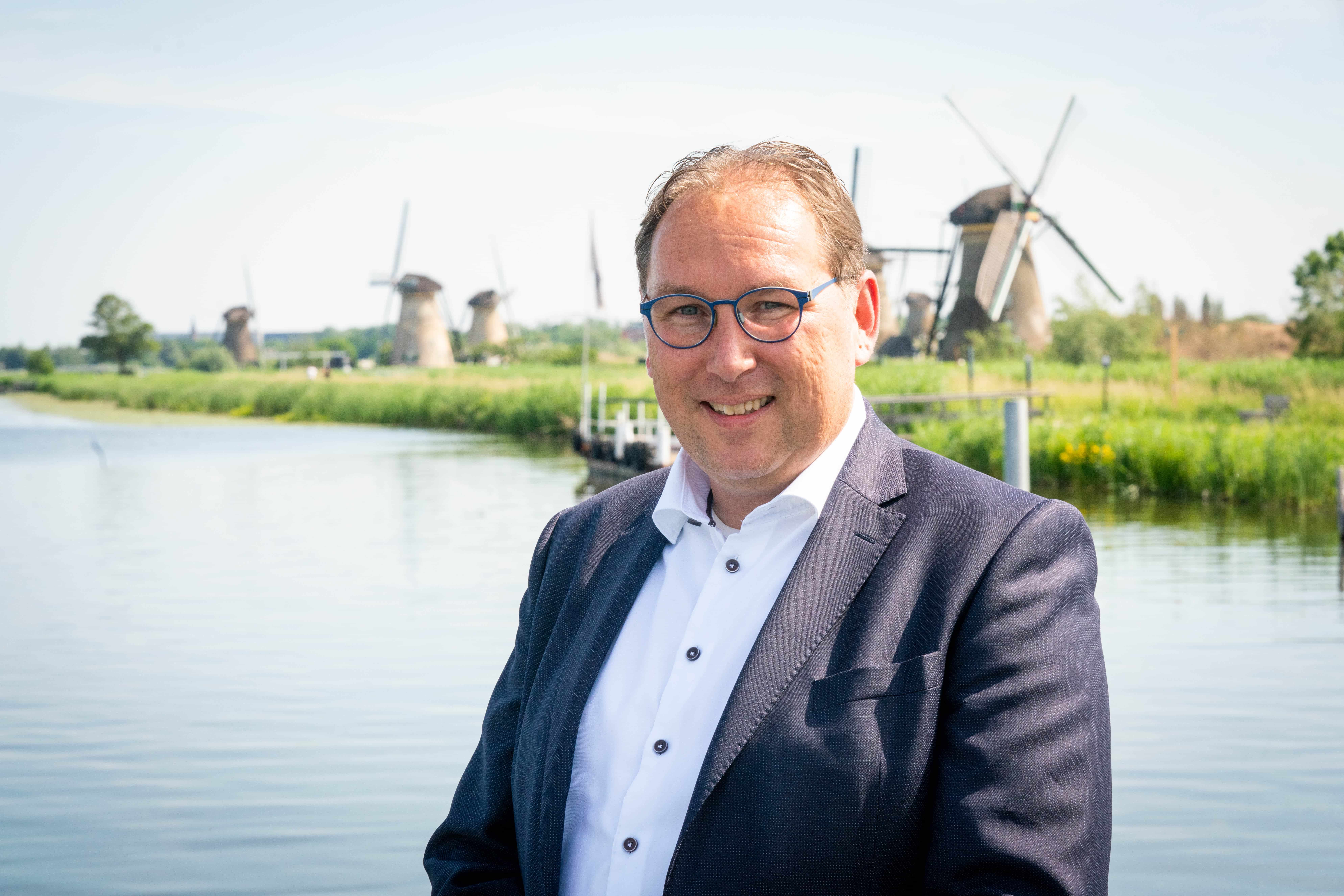 Directeur-bestuurder Peter-Jan van Steenbergen in UNESCO Werelderfgoed Kinderdijk met op de achtergrond de molens van dit unieke gebied.