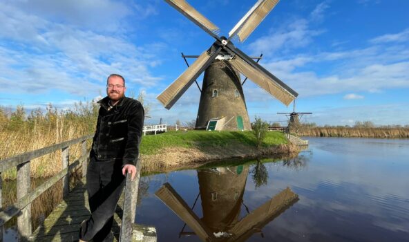 Molenaar Marc Polderman poseert voor molen Nederwaard 5 in Kinderdijk