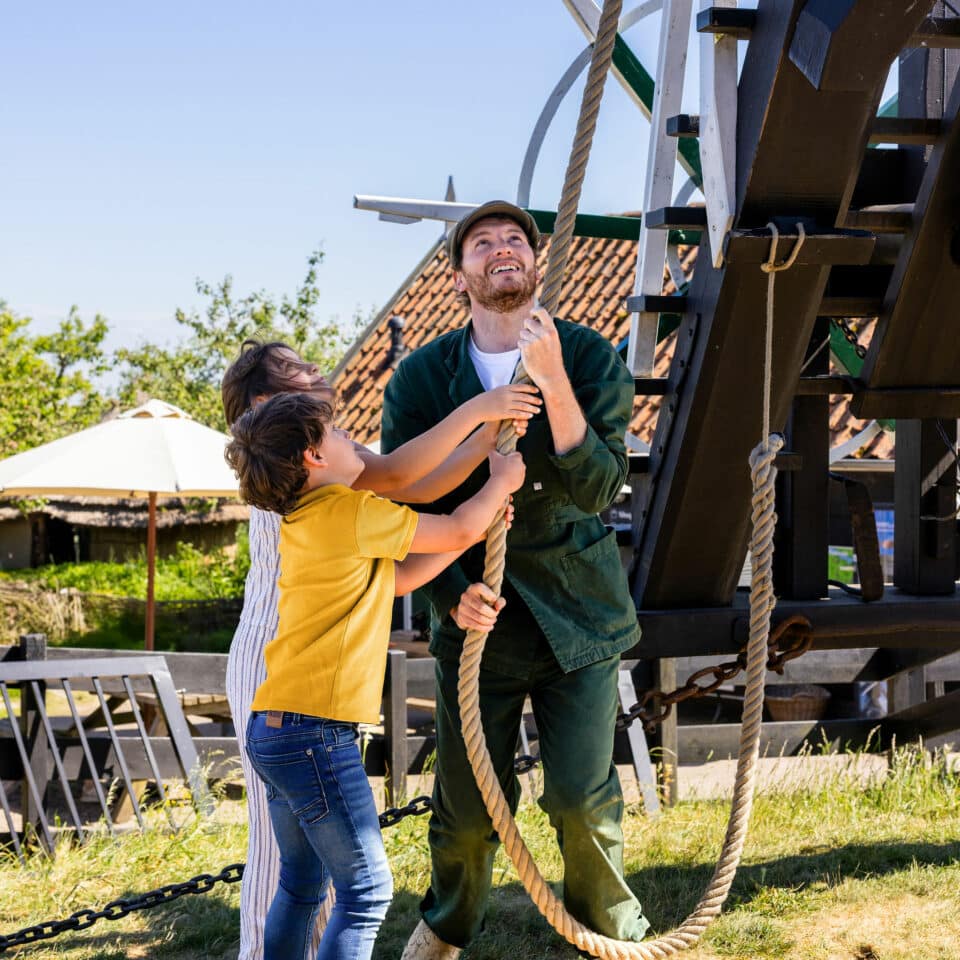 Molenaar laat kinderen ontdekken hoe ze molen op de rem/loslaten (de vang) door aan een touw te trekken.